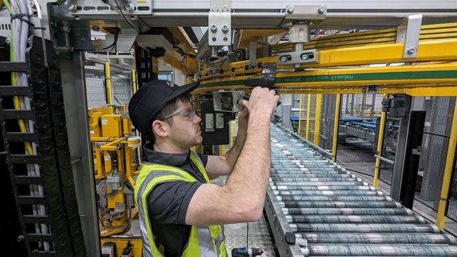 Alastair working on an automated packaging line above a roller conveyor